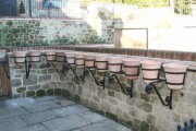 Plant pot holders for courtyard wall